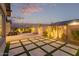 Wonderful backyard patio with modern pavers and decorative landscape lighting at dusk at 9749 E Ripple Dr, Mesa, AZ 85212