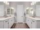 Dual sink bathroom with matching mirrors, white countertops, and wood-look flooring at 9749 E Ripple Dr, Mesa, AZ 85212