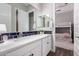 Bathroom with double sinks, shaker cabinets, and access to the adjacent bedroom at 9749 E Ripple Dr, Mesa, AZ 85212