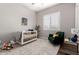 Cozy Bedroom with a white crib, green armchair, plush rug and abundant natural light at 9749 E Ripple Dr, Mesa, AZ 85212