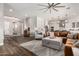 Open-concept living room with wood floors, modern lighting, and seamless flow to the kitchen at 9749 E Ripple Dr, Mesa, AZ 85212