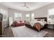 Spacious main bedroom with large windows, a ceiling fan and stylish furniture at 9749 E Ripple Dr, Mesa, AZ 85212