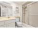 Bright bathroom featuring a single sink vanity and a walk-in shower with sliding glass doors at 10103 W Saddle Ridge Dr, Sun City, AZ 85373