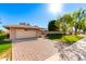 Charming single-story home with a brick facade, lush lawn, and a two-car garage at 10103 W Saddle Ridge Dr, Sun City, AZ 85373