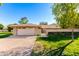 Charming single-story home with a brick facade, lush lawn, and a two-car garage at 10103 W Saddle Ridge Dr, Sun City, AZ 85373