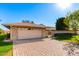 Charming single-story home with a brick facade, lush lawn, and a two-car garage at 10103 W Saddle Ridge Dr, Sun City, AZ 85373