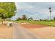 Picturesque golf course fairway with manicured grass, palm trees, and a smooth paved golf cart path at 10103 W Saddle Ridge Dr, Sun City, AZ 85373