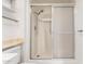 Enclosed shower with sliding glass door, handheld shower, and built in seat at 10103 W Saddle Ridge Dr, Sun City, AZ 85373