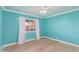 Comfortable bedroom with hardwood floors, a ceiling fan, and bright turquoise walls at 1021 E Myrtle Ave, Phoenix, AZ 85020