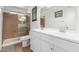 Bathroom featuring double sinks, a shower with glass doors, and neutral-toned tiled flooring at 1022 W Watson Dr, Tempe, AZ 85283