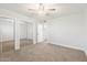 Bedroom featuring carpet, sliding mirror closet doors, and a ceiling fan at 10404 W Tropicana S Cir, Sun City, AZ 85351