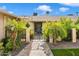 Inviting entrance with desert landscaping, decorative metal gate, and security system sign at 10404 W Tropicana S Cir, Sun City, AZ 85351