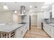 Modern kitchen features stainless steel hood, large center island, and quartz countertops at 10404 W Tropicana S Cir, Sun City, AZ 85351