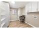 Bright laundry room featuring laminate floors, cabinets, and a utility sink at 10404 W Tropicana S Cir, Sun City, AZ 85351