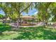 Large park gazebo with shade structures, swings, and seating amidst lush green trees and lawns at 1110 W Seagull Dr, Chandler, AZ 85286