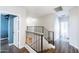 Bright hallway featuring wood floors, black metal railings, and multiple doorways at 1249 W Seascape Dr, Gilbert, AZ 85233