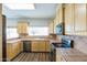 Well-lit kitchen with wood floors, stainless steel appliances, and natural wood cabinets at 1249 W Seascape Dr, Gilbert, AZ 85233