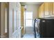 Laundry room with patterned tile flooring, light cabinets, and modern washer and dryer at 1249 W Seascape Dr, Gilbert, AZ 85233