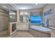 Bathroom with soaking tub, tile surround, dual vanities, granite countertops, decorative lighting, and walk-in shower at 12859 W Calle De Baca --, Peoria, AZ 85383