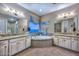 Luxury bathroom features a soaking tub with tile surround, dual vanities with granite countertops, and decorative lighting at 12859 W Calle De Baca --, Peoria, AZ 85383