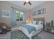 Cozy bedroom features a comfortable bed, stylish furnishings, a ceiling fan, and natural light from the large window at 12859 W Calle De Baca --, Peoria, AZ 85383