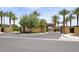 Gated community entrance featuring lush landscaping, palm trees, and decorative masonry at 12859 W Calle De Baca --, Peoria, AZ 85383