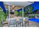 Covered outdoor kitchen featuring a bar, grill, fire feature, and a view of the sparkling pool at 12859 W Calle De Baca --, Peoria, AZ 85383