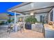 Well-equipped outdoor kitchen with a grill, cooktop, bar seating, and easy access to backyard amenities at 12859 W Calle De Baca --, Peoria, AZ 85383