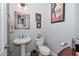 Stylish powder room with pedestal sink, decorative mirror, and a classic toilet at 12859 W Calle De Baca --, Peoria, AZ 85383