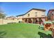 Expansive backyard featuring a lush lawn and covered patio with stylish drapes, perfect for outdoor living and entertaining at 1322 S 118Th Dr, Avondale, AZ 85323