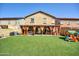 Backyard featuring an artificial lawn, covered patio with orange curtains, offering a low-maintenance outdoor space at 1322 S 118Th Dr, Avondale, AZ 85323