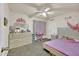 Bright bedroom with a ceiling fan, a dresser with mirror and a cozy bed with pink sheets at 1322 S 118Th Dr, Avondale, AZ 85323