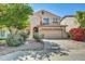 Two-story home featuring a neutral color scheme, desert landscaping, and a two car garage at 1322 S 118Th Dr, Avondale, AZ 85323