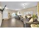 A spacious living room with wood look tile flooring and neutral decor with large windows at 1322 S 118Th Dr, Avondale, AZ 85323