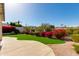 A shot of the backyard with artificial grass, mature trees, and a gravel border at 1331 E Voltaire Ave, Phoenix, AZ 85022