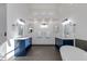 Bathroom showcasing navy blue vanity with double sinks, decorative mirrors and standalone tub at 1331 E Voltaire Ave, Phoenix, AZ 85022