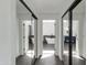 Hallway with black framed sliding mirror closet doors leading to bathrooms with vanities and standalone tub at 1331 E Voltaire Ave, Phoenix, AZ 85022