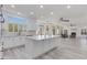 Bright open concept kitchen with white cabinets, an island, and views of the backyard and Gathering room at 1331 E Voltaire Ave, Phoenix, AZ 85022