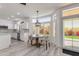 Bright kitchen boasts white cabinets, a marble backsplash, and a breakfast nook with backyard views at 1331 E Voltaire Ave, Phoenix, AZ 85022
