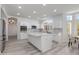 Open kitchen features white cabinets, a large island with marble countertop, and stainless steel appliances at 1331 E Voltaire Ave, Phoenix, AZ 85022