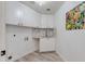 A laundry room featuring vinyl flooring, cabinet storage and utility sink at 1331 E Voltaire Ave, Phoenix, AZ 85022