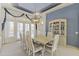 Formal dining space with a large table, white chairs, stylish drapery, and plenty of light at 13514 W Wagon Wheel Dr, Sun City West, AZ 85375