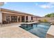 Beautiful backyard featuring an outdoor kitchen, covered patio, pool, and lush landscaping at 14010 N 12Th St, Phoenix, AZ 85022