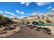 Expansive backyard with pool, waterfall, lounge chairs, fire pit, and desert landscaping at 14258 W Lisbon Ln, Surprise, AZ 85379