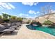 Spacious backyard featuring a pool with waterfall, lounge chairs, and desert landscaping at 14258 W Lisbon Ln, Surprise, AZ 85379