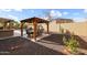 Backyard with a gazebo featuring a dining table, overlooking the pool with rock waterfall at 14258 W Lisbon Ln, Surprise, AZ 85379