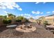 Backyard features a fire pit area with seating and desert landscaping and a pool with waterfall feature at 14258 W Lisbon Ln, Surprise, AZ 85379