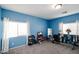 Bright exercise room with ample natural light, carpet flooring, and a variety of workout equipment at 14258 W Lisbon Ln, Surprise, AZ 85379
