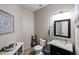 Tastefully decorated half bathroom featuring granite countertops, dark vanity, and neutral wall colors at 14258 W Lisbon Ln, Surprise, AZ 85379