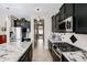 Sleek kitchen featuring stainless steel appliances, granite countertops, and dark cabinets at 14258 W Lisbon Ln, Surprise, AZ 85379